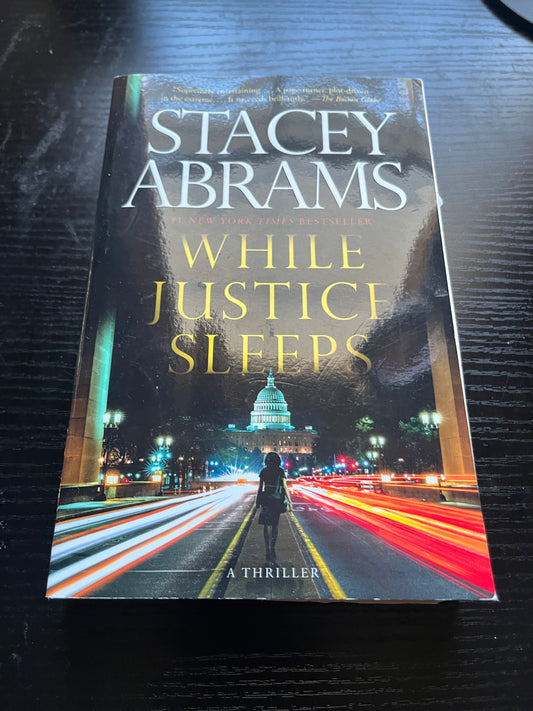 WHILE JUSTICE SLEEPS: A Thriller by Stacey Abrams